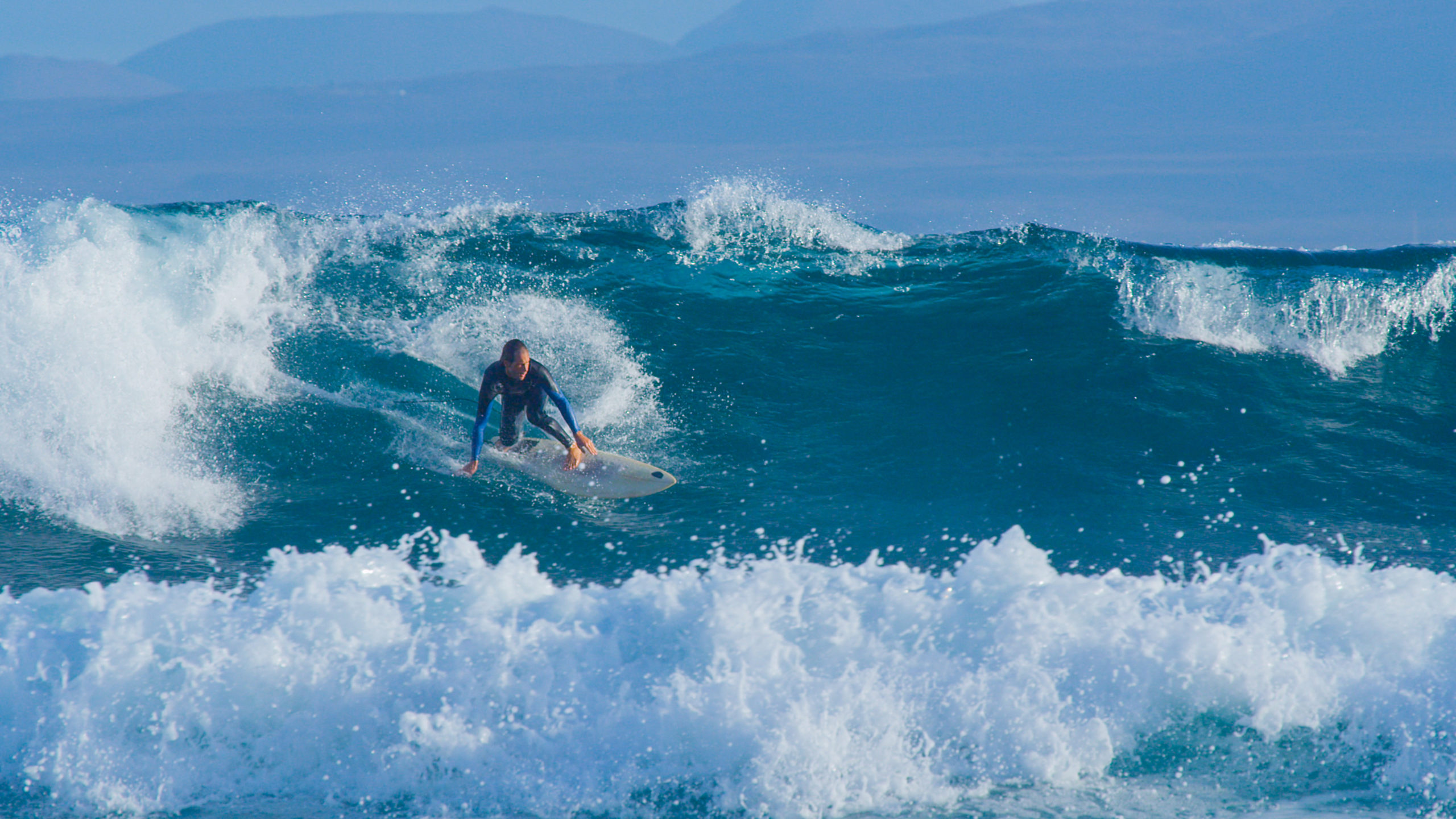 a man riding a wave on a surfboard in the ocean